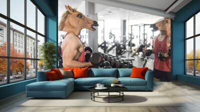 Horse face man training lifting weights in gym looking his reflection in mirror Wall mural