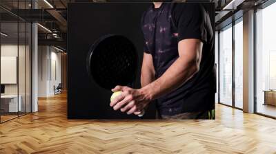 Man ready for paddle tennis serve in studio shot, anonymous pose Wall mural