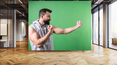 man with beard and hooded t-shirt trains martial arts isolated on chroma key green background Wall mural