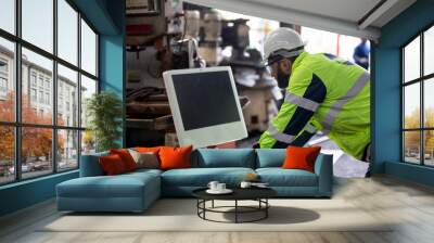 Engineer working by using a laptop at factory  Wall mural