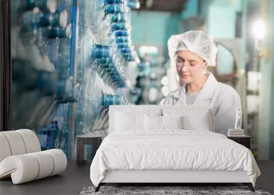 Female worker inspecting water bottle on production line in spring water factory Wall mural