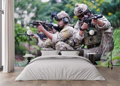 Military army soldiers tactical team, commando group moving cautiously in forest area, kneeling and looking around, covering comrades, controlling sectors. Commander showing halt or stop hand signal Wall mural