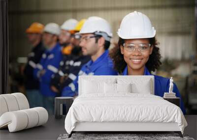 Young confident leader of team standing in front of factory workers Wall mural