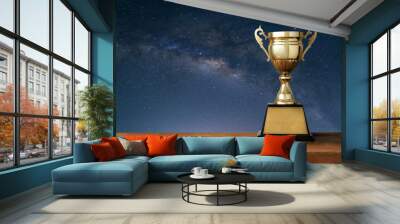 champion golden trophy on wood table with Milky Way background Wall mural