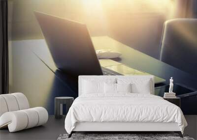 laptop and mobile phone on the work desk in a home office with morning light. Wall mural