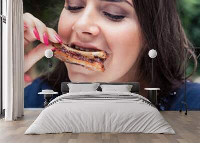 Young beautiful woman eating grilled ribs. Wall mural