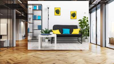 A large bright living room in the house with black furniture and accessories in blue and yellow. Modern interior design of the apartment. Wall mural