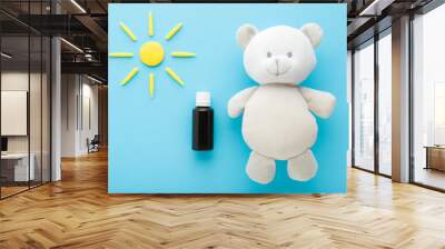 Brown glass bottle of d vitamin, white soft fluffy teddy bear and yellow sun shape on light blue table background. Pastel color. Closeup. Daily receiving vitamins for baby. Top down view. Wall mural