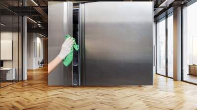 hand in protective glove with rag cleaning kitchen equipment in the professional kitchen. stainless  Wall mural