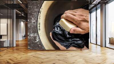 Poor man's hands washing dirty clothes in the old metallic bowl. Poverty concept. Clothes care. Rural life.  Wall mural