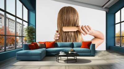 woman with comb brushing her wet blonde hair after shower on the gray background. cares about a heal Wall mural