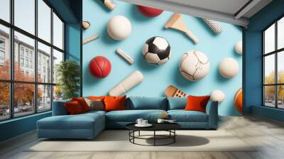 A colorful arrangement of various sports equipment including balls, rackets, and accessories on a blue background Wall mural