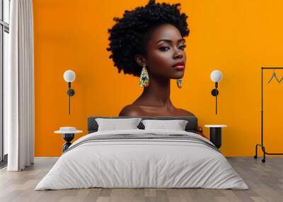 A confident young woman showcases traditional African fashion against a vibrant orange backdrop in a striking portrait Wall mural