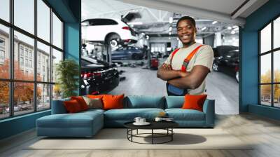 African man mechanic in uniform at the car repair station, portrait Wall mural