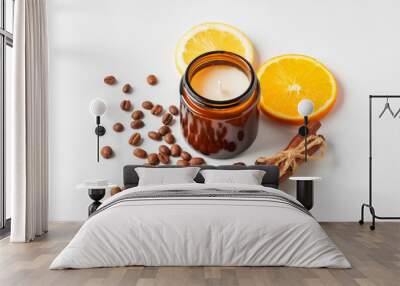 Aromatic candle, coffee beans, orange slices, and cinnamon sticks arranged on a white background Wall mural