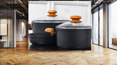 Black cookware on induction stove against grey wall Wall mural