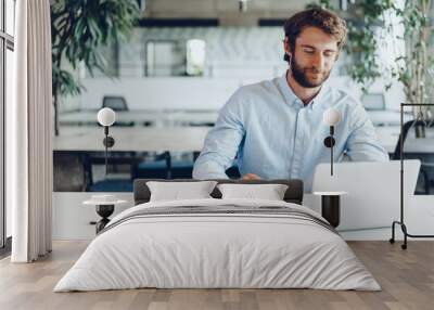 Businessman in shirt working on his laptop in an office. Open space office Wall mural