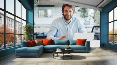 Businessman in shirt working on his laptop in an office. Open space office Wall mural