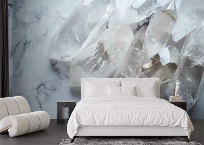 Clear quartz crystals arranged elegantly on a marble surface, showcasing natural beauty and unique formations under bright light Wall mural