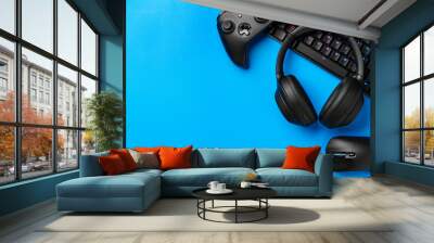 Computer keyboard and joystick on blue background top view Wall mural