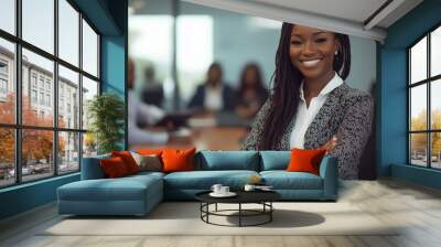 Confident businesswoman standing in a modern office with colleagues engaged in discussion during a meeting Wall mural