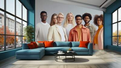 Diverse group of individuals posing together in modern attire against a minimalist backdrop Wall mural