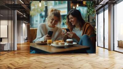 Friends enjoying brunch and checking their phones at a cozy café during a sunny autumn day in the city Wall mural