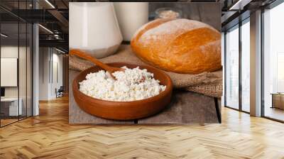 Glass jar of milk, bowl of cottage cheese and bread on wooden table Wall mural