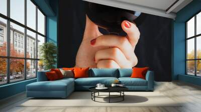 Hand holding glass of red wine on dark grey background Wall mural