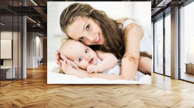 happy family. mother playing with her baby in the bedroom. Wall mural