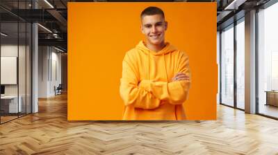 Happy smiling young man looking to camera over yellow background Wall mural