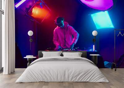 Male DJ playing music in the night club Wall mural