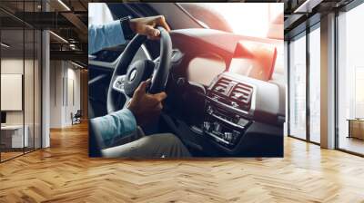 Male hands holding steering wheel of a car Wall mural