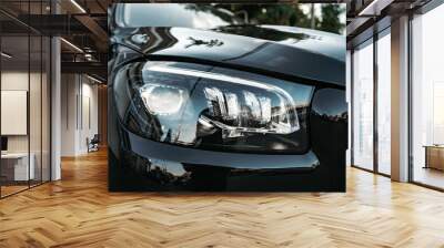 Modern car headlight of a black luxury car close up Wall mural