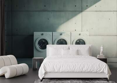 Modern laundry room with three white washing machines against a concrete wall in a well-lit space Wall mural