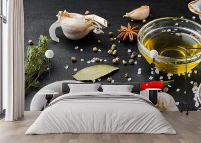 Olive oil, herbs and spices on black background Wall mural