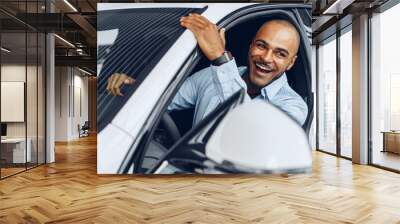 Portrait of a handsome happy African American man sitting in his newly bought car Wall mural