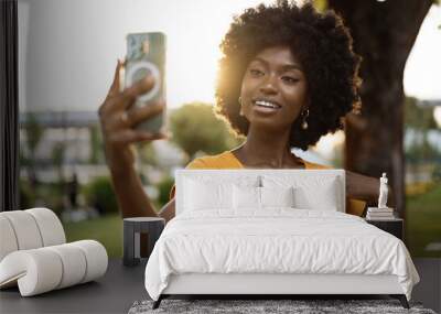 Portrait of a young afro american woman taking a selfie outdoor Wall mural