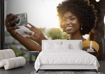 Portrait of a young afro american woman taking a selfie outdoor Wall mural