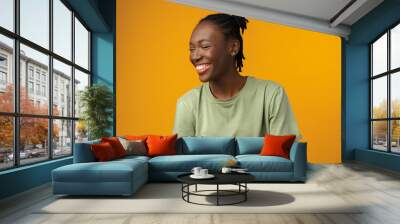 Portrait of beautiful positive african american woman in yellow studio Wall mural