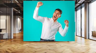 Portrait of excited, successful man raising hands up Wall mural