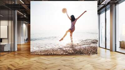 Portrait of young woman walking on the beach on sunrise Wall mural