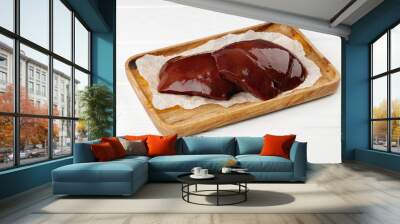 Raw beef liver on wooden board on table Wall mural