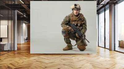 Soldier in camouflage holding rifle Wall mural