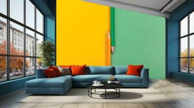 Two pencils .lie at the junction of two colored papers green and yellow top view Wall mural