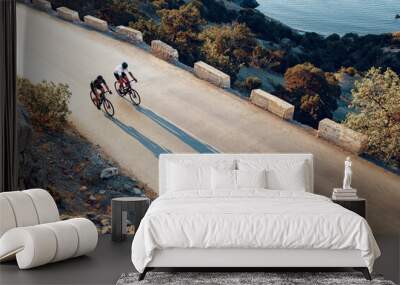 Two professional male cyclists riding their racing bicycles in the morning together Wall mural