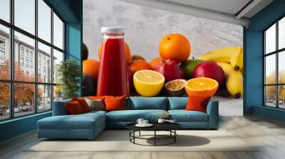 Various fruits and freshly squeezed fruits juice in bottle on gray background Wall mural