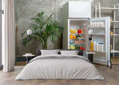 White Refrigerator With Open Door Showing Food Inside, Grey Concrete Wall, Wooden Floor, and Plant Wall mural