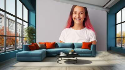 Young girl teenager with pink hair happy and smiling over gray background Wall mural