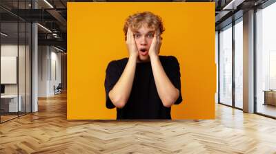 Young man over yellow background with surprise facial expression Wall mural